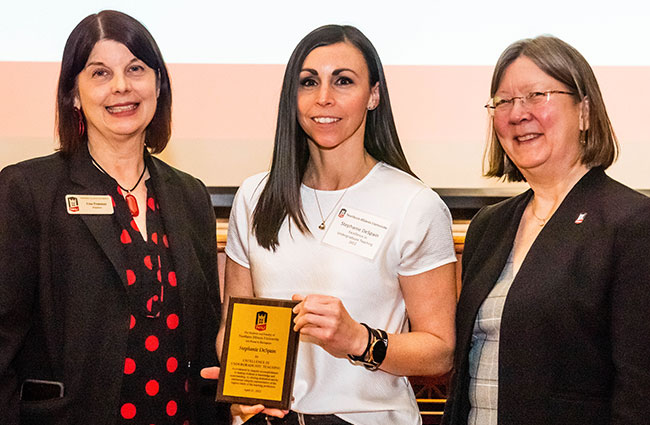 Stephanie DeSpain (center) celebrates her Excellence in Undergraduate Teaching Award with NIU President Lisa Freeman (left) and NIU Provost Beth Ingram.