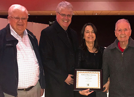 Leslie A. Sassone celebrates her Honors Great Professor Award in 2018 with father-in-law Don Coykendall (far left), husband Mark Coykendall and father Nick Sassone (right).