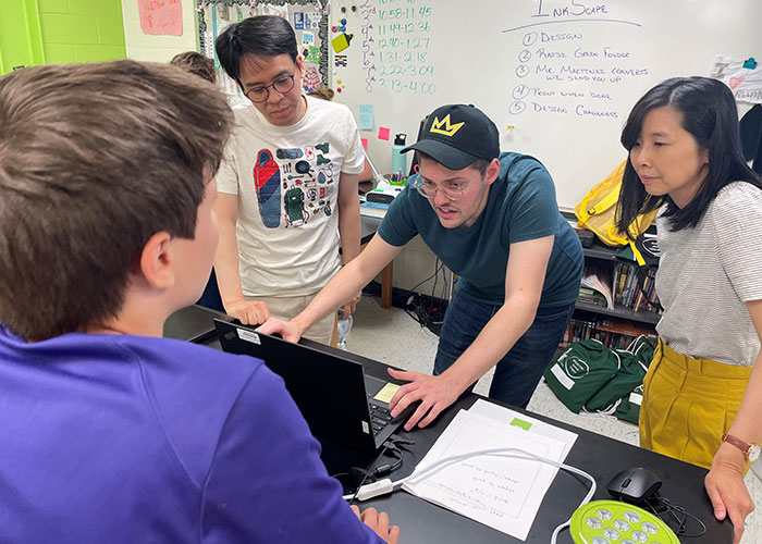 Eric Monsu Lee, Jacob Martinez and Pi-Sui Hsu help a summer camp participant.