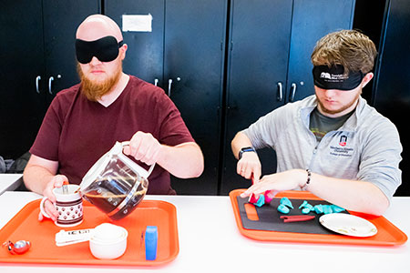Graduate students in NIU’s Visual Disabilities program practice basic life skills while wearing sleep-shades.