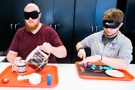 NIU Visual Disabilities students practice performing everyday activities while wearing sleep shades.