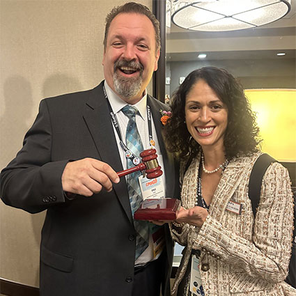 Dale Fisher, outgoing president of the American Association of School Personnel Administrators, congratulates his successor: Monica Schneider.