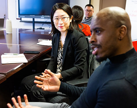 Injung Lee listens as Quortne Hutchings speaks at a Department of Counseling and Higher Education faculty meeting.