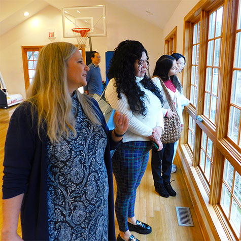 Lisa Kambich shows the NIU visitors the view outside from the gym her father, Tony, made sure was part of the school.