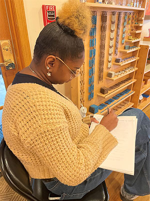 An NIU student takes notes of what she observes in a Montessori multi-age classroom.