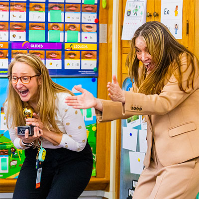 Lisa Robinson celebrates with Jennifer Stark, executive director of the Golden Apple Foundation.
