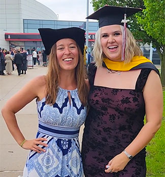 Congratulations! Jenn Jacobs cheers on FLEX alumna Huntleigh Wozniak outside commencement.